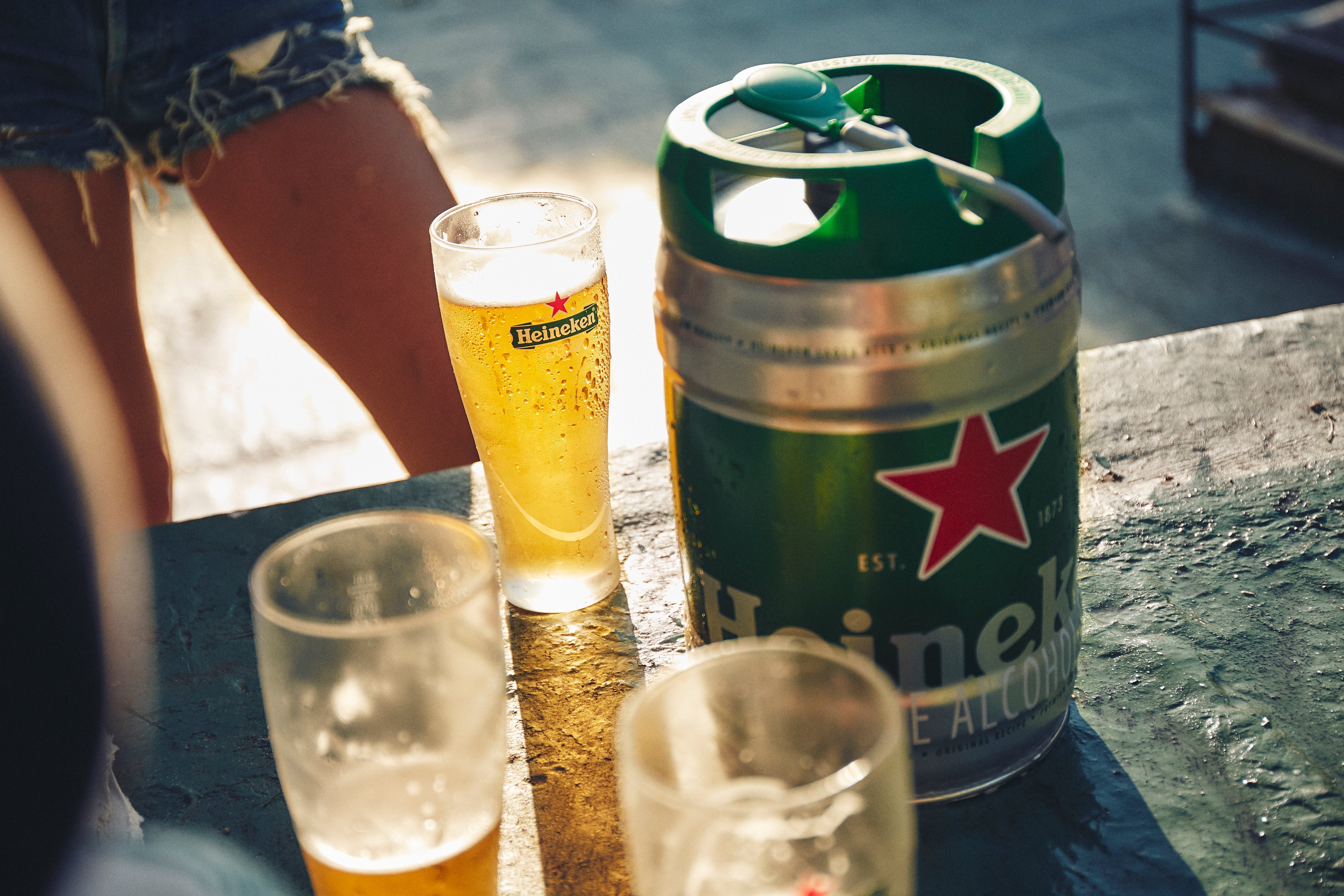 Heineken keg and glasses on a table outdoors