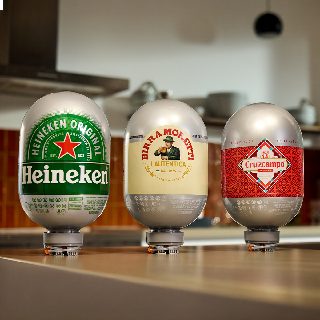 Three BLADE beer kegs with Heineken, Birra Moretti, and Cruzcampo labels on a kitchen counter.