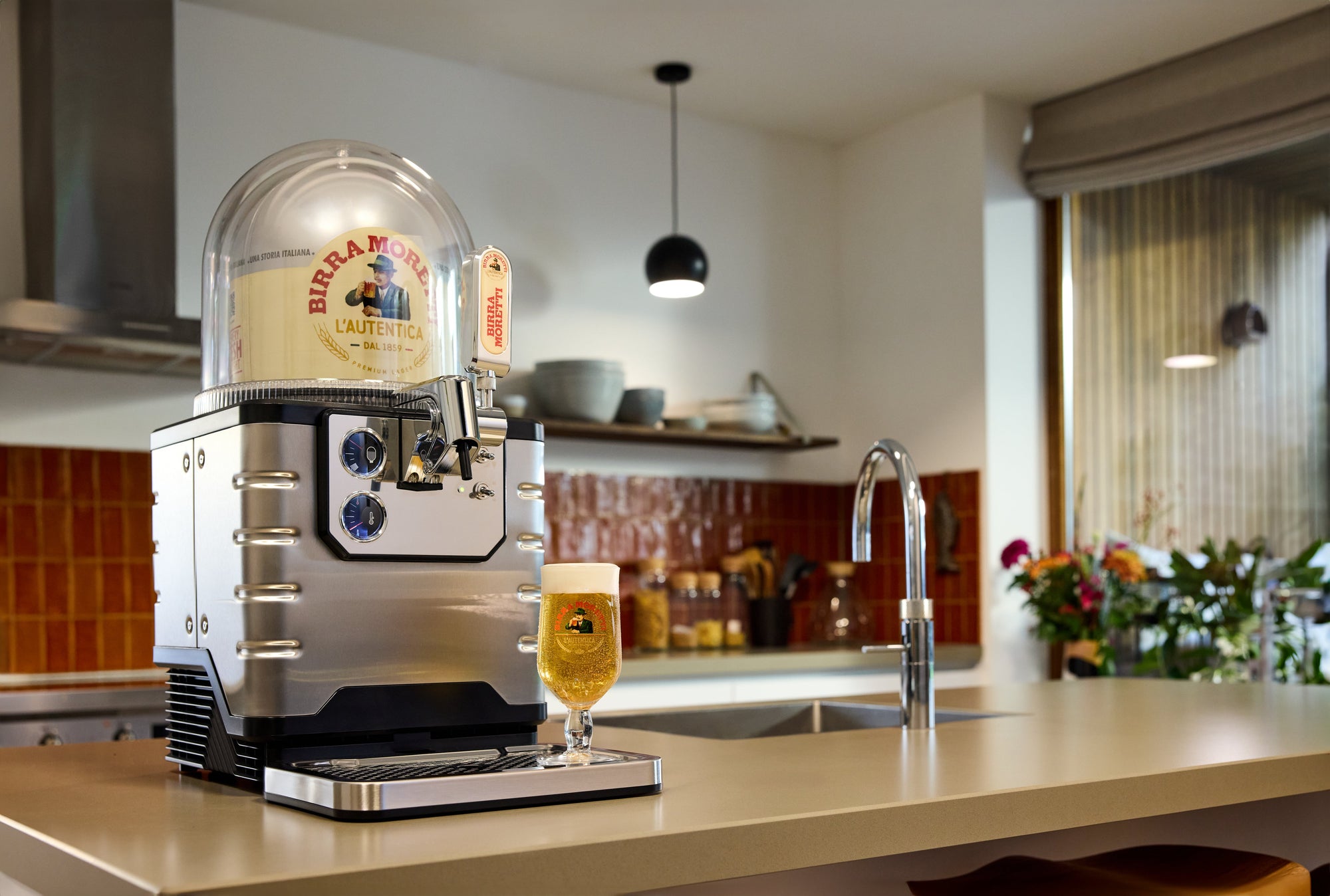 BLADE beer machine on a kitchen counter with a glass of beer, surrounded by kitchen items.