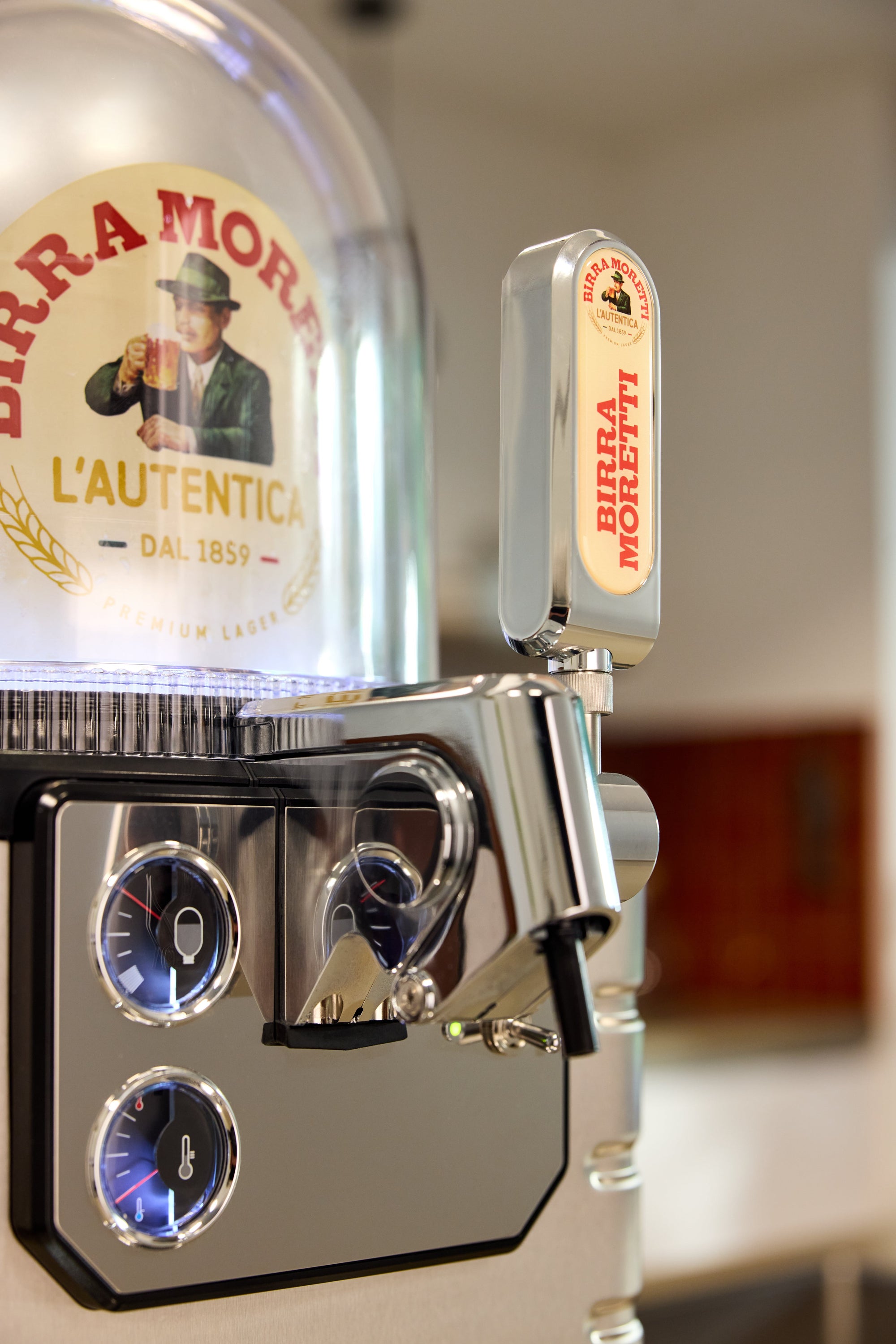 A detailed close-up of a BLADE beer machine, highlighting its unique design features, including gauges and a Birra Moretti branded tap handle.