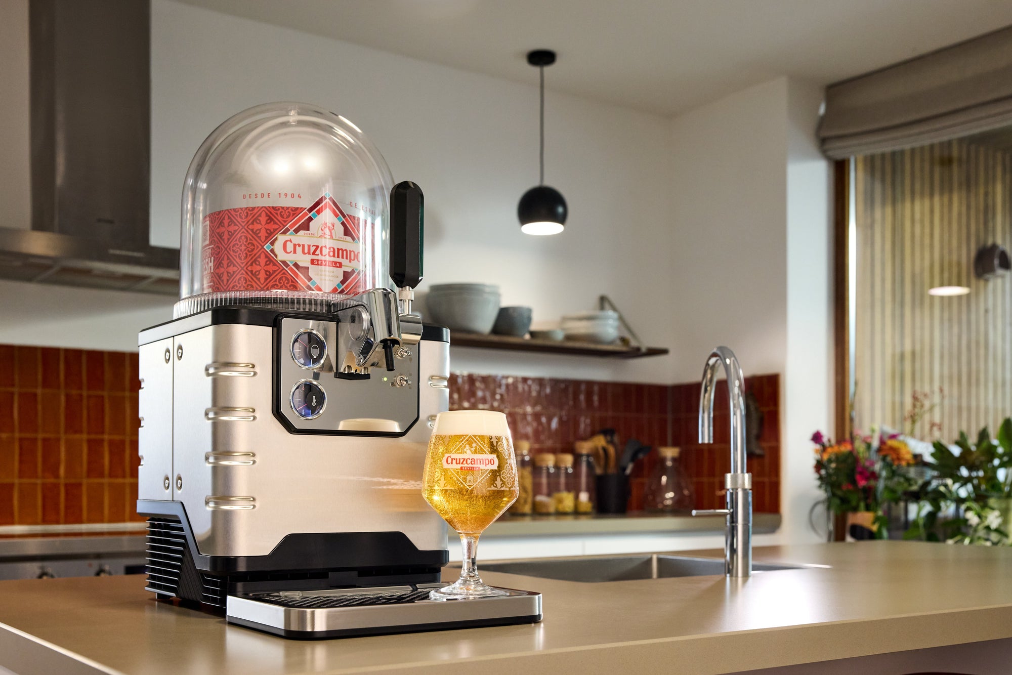 BLADE beer dispenser and a glass of beer on a kitchen counter.
