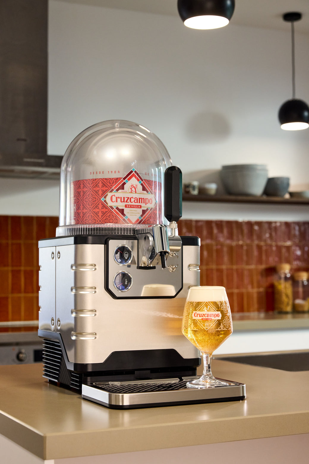 A BLADE beer dispenser with a glass of beer on a kitchen counter.