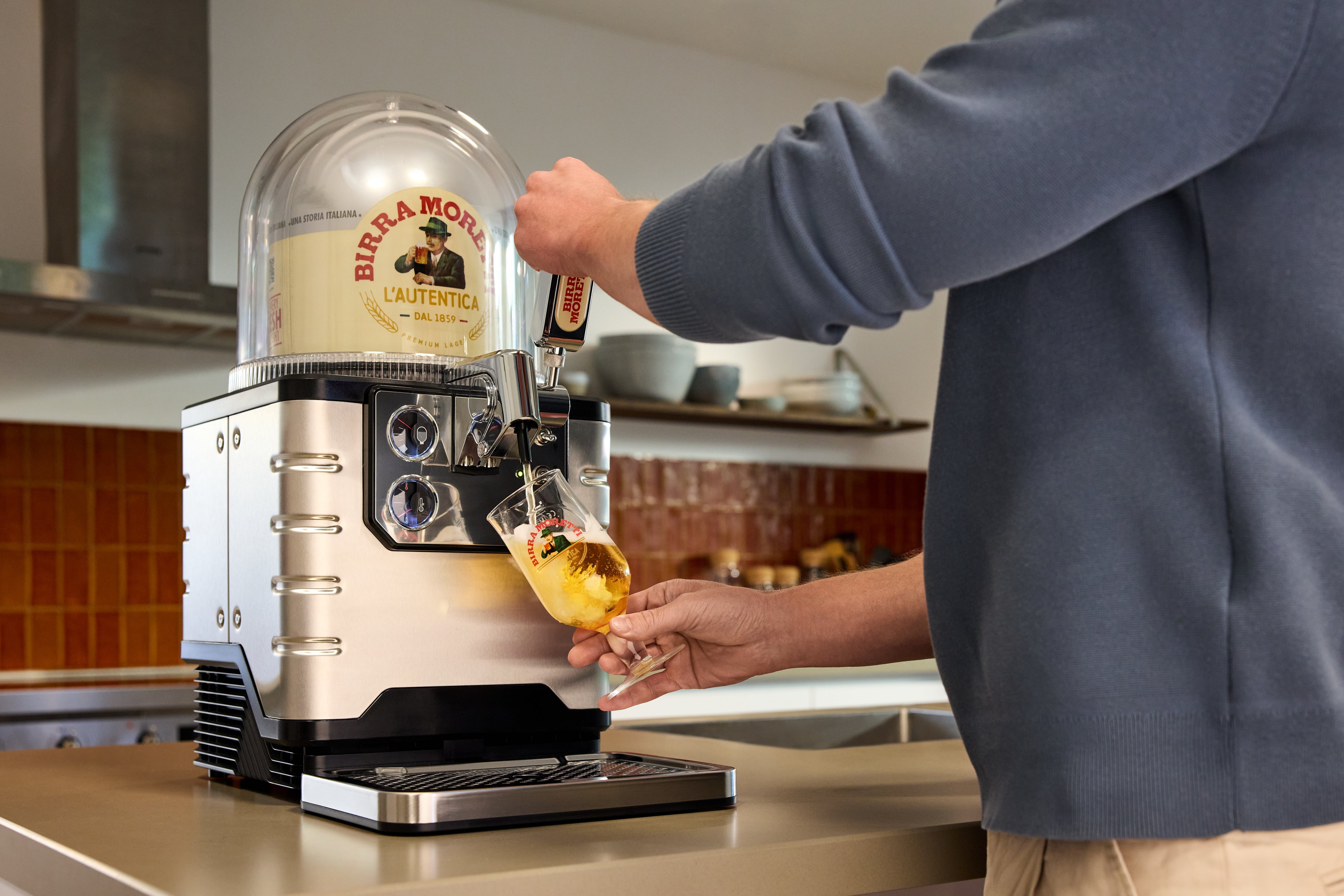 Person using a BLADE beer machine in a kitchen setting