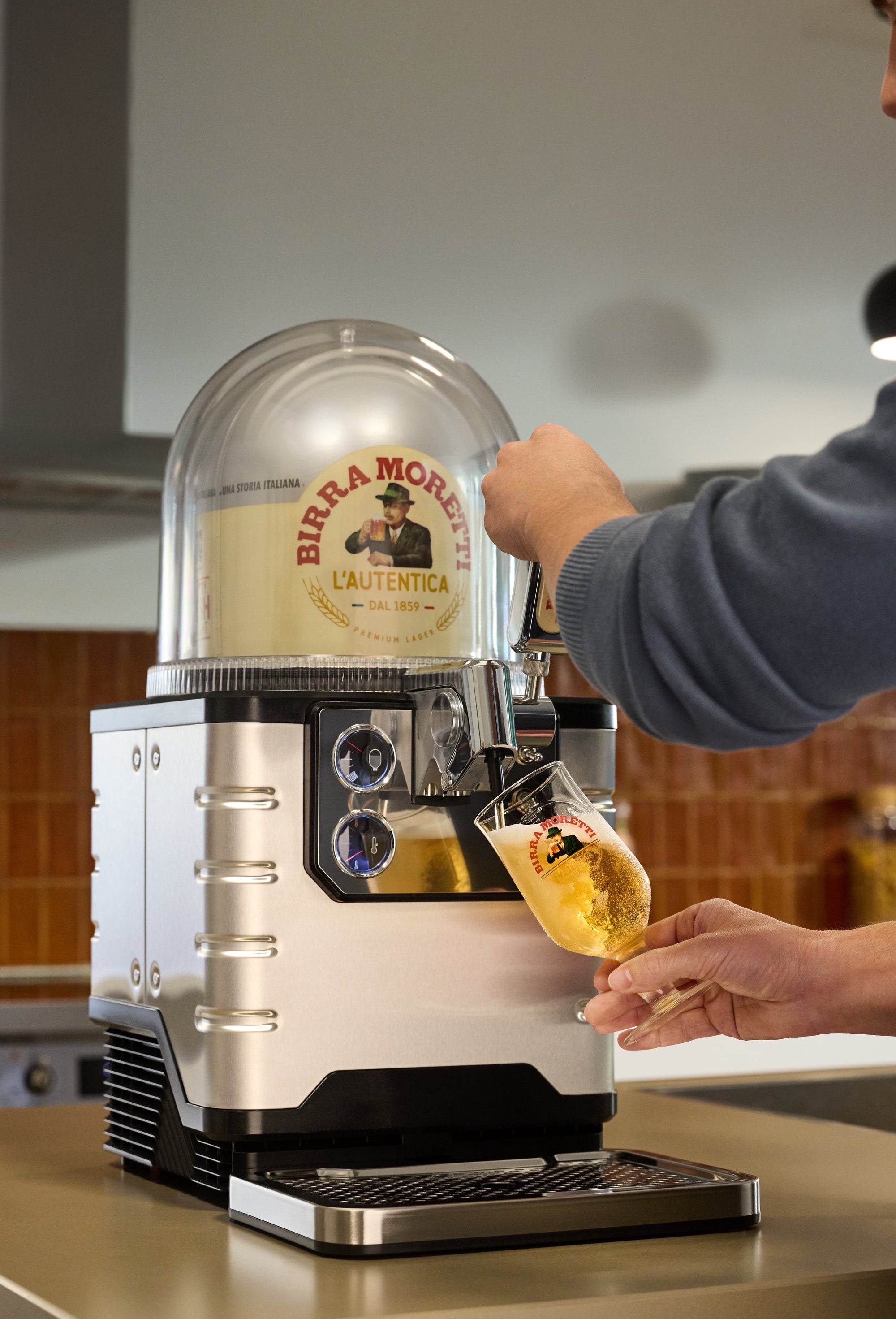 Person using a BLADE beer machine in a kitchen setting.