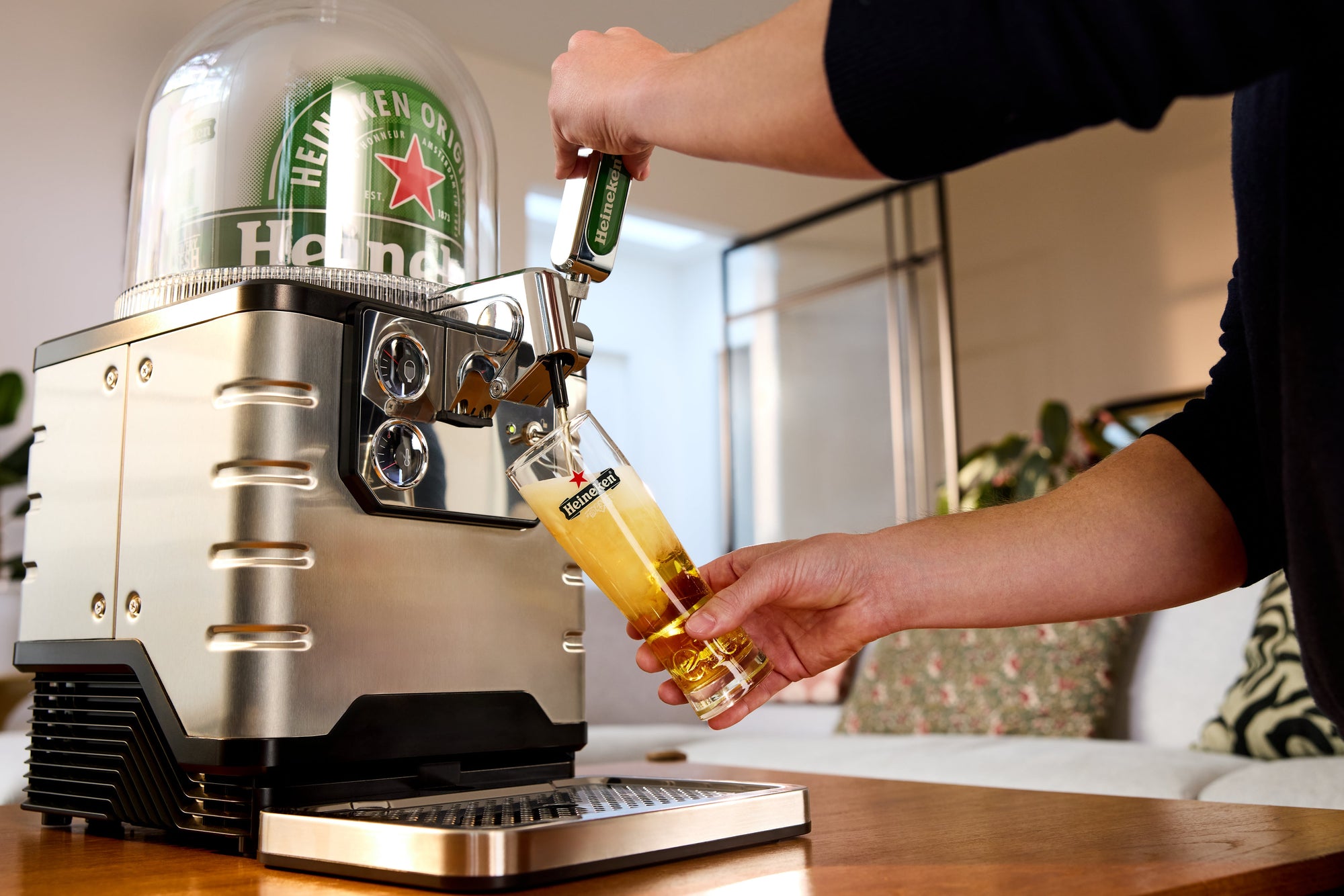 Person pouring beer from a Heineken BLADE beer tap into a glass.