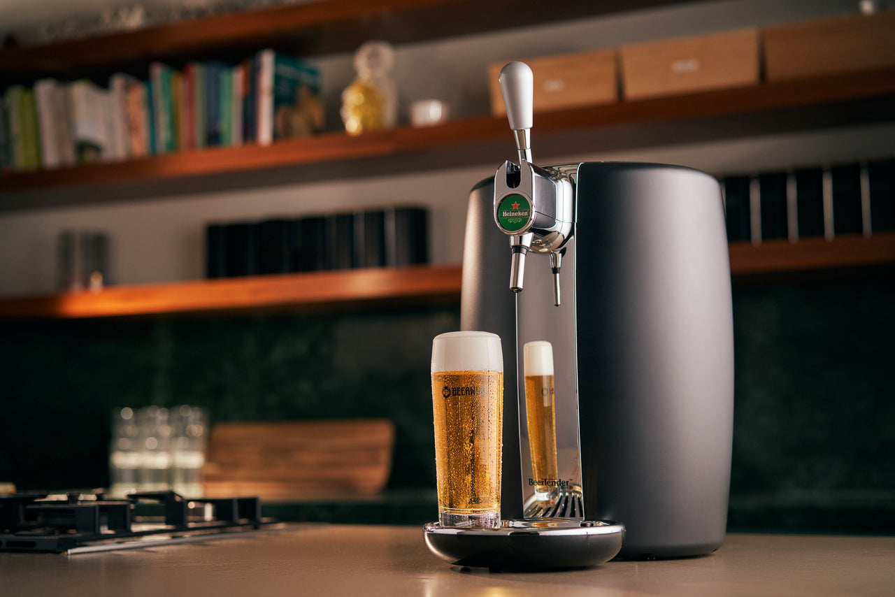 A BeerTender beer machine with a glass of beer on a bar counter.