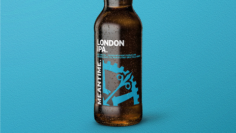 A cold bottle of Meantime London IPA against a blue background.