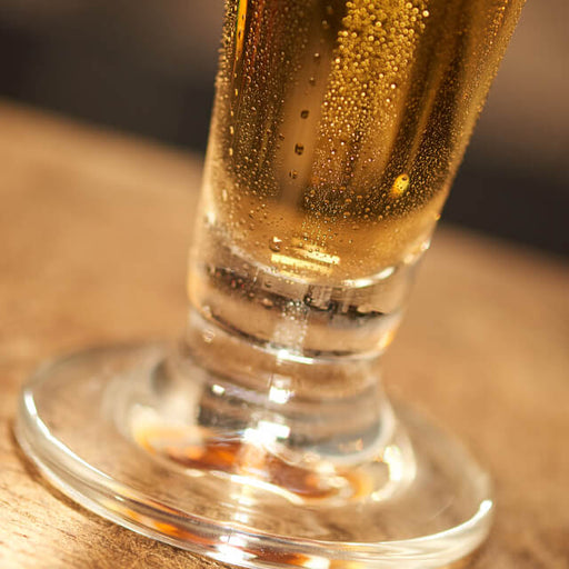 The bottom of a beer glass, filled with a lager beer