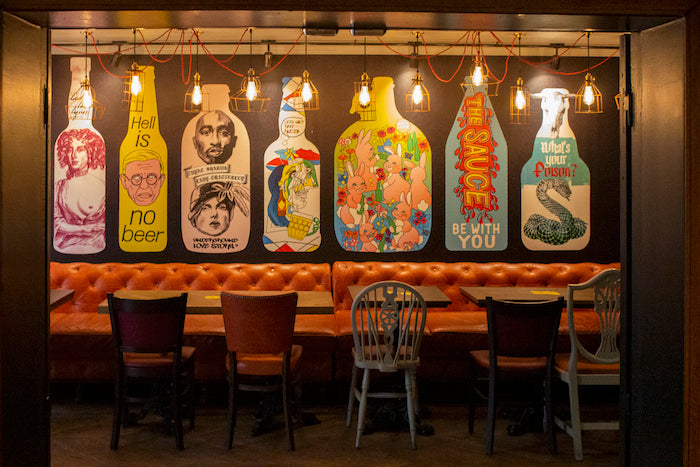 View of FrogPub in Paris, with a vibrant and inviting facade behind the seating area.