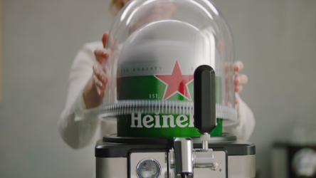 A person places a dome cover over a BLADE beer dispenser to keep the beer cool. They then switch on the appliance using the side switch with lightbulb icons to activate the lighting.