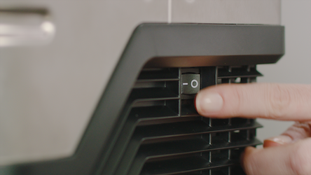 An image of turning on the machine by pressing the ON-OFF switch to the right.