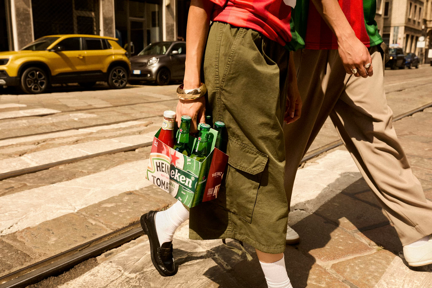 People walking on the street holding the 6 pack with the HEINZ Heineken collaboration