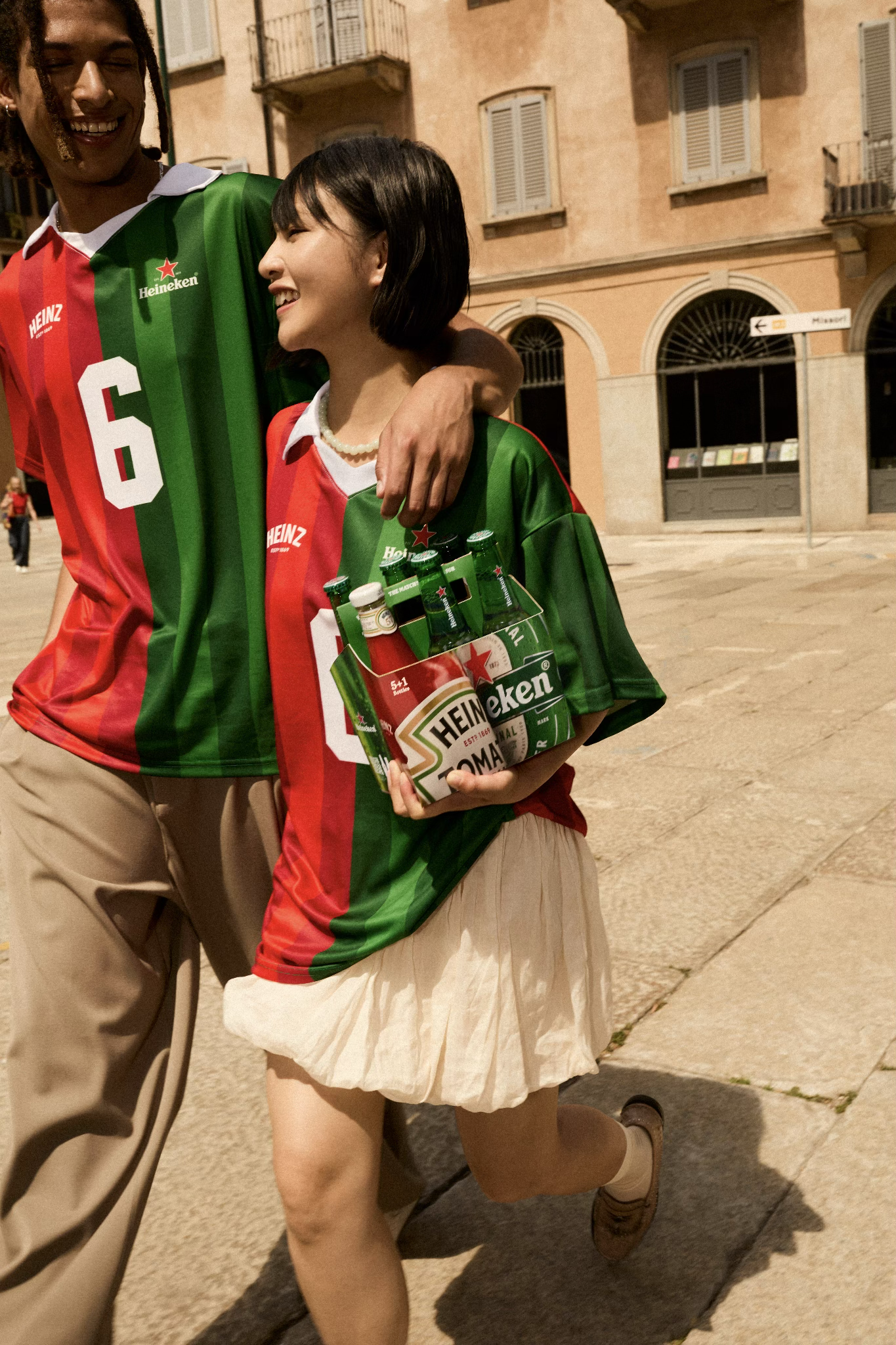 People walking on the street holding the 6 pack with the HEINZ Heineken collaboration