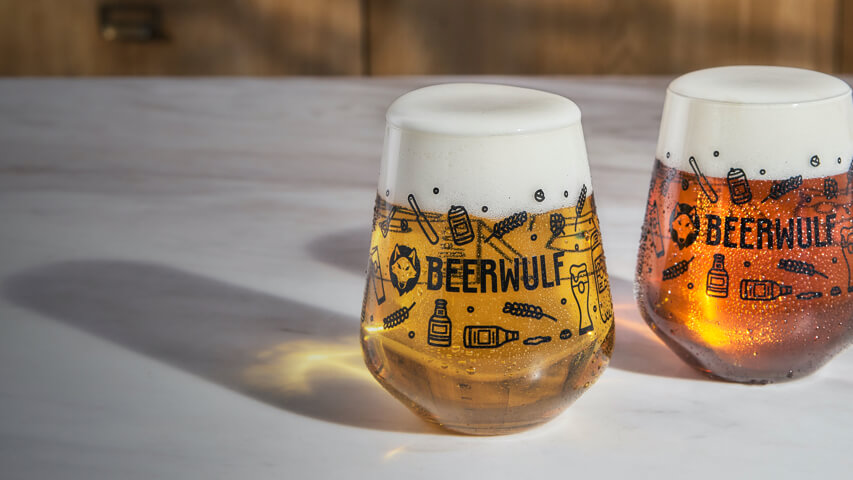 Beer-related merchandise, including glassware, displayed on a wooden surface.